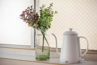 a vase with flowers in it sitting on a table next to a water pitcher at \u30d2\u30eb\u30ba\u99d2\u8fbc in Tokyo