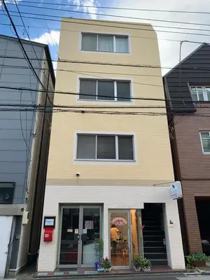 a yellow and white building with a store at \u30d2\u30eb\u30ba\u99d2\u8fbc in Tokyo