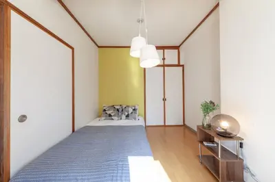 a bedroom with a bed with a blue blanket at \u30d2\u30eb\u30ba\u99d2\u8fbc in Tokyo