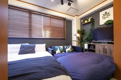 a bedroom with two beds and a flat screen tv at \u30d2\u30eb\u30ba\u99d2\u8fbc in Tokyo
