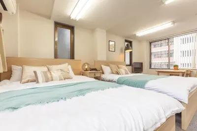 two large beds in a room with a window at \u7b2c\u4e09\u5929\u53f0\u30d3\u30eb in Tokyo