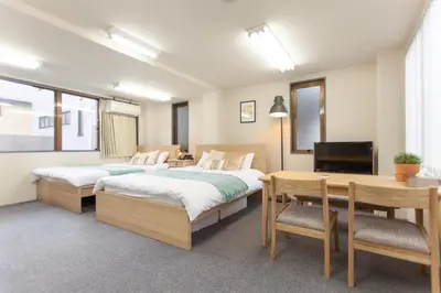 a bedroom with two beds and a desk and a television at \u7b2c\u4e09\u5929\u53f0\u30d3\u30eb in Tokyo