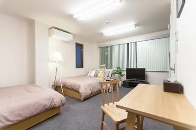 a room with two beds and a tv and a table at \u7b2c\u4e09\u5929\u53f0\u30d3\u30eb in Tokyo