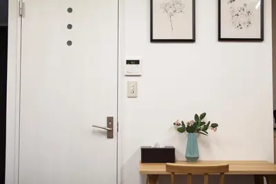 a door with a vase of flowers on a table at \u7b2c\u4e09\u5929\u53f0\u30d3\u30eb in Tokyo
