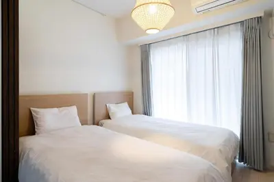 two beds in a room with a window at Tokyo Sunshine Tower in Tokyo