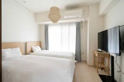 a hotel room with two beds and a flat screen tv at Tokyo Sunshine Tower in Tokyo