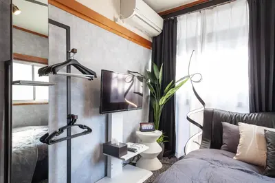 a bedroom with a bed and a tv on a wall at \u690e\u540d\u753a\u30cf\u30a6\u30b9 in Tokyo