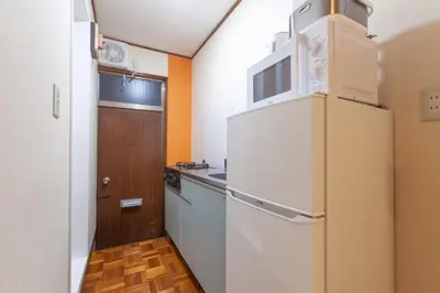 a kitchen with a white refrigerator and a sink at \u690e\u540d\u753a\u30cf\u30a6\u30b9 in Tokyo