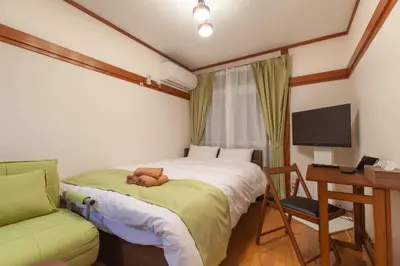 a bedroom with a bed with a teddy bear on it at \u690e\u540d\u753a\u30cf\u30a6\u30b9 in Tokyo