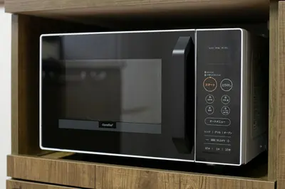 a microwave oven sitting on a wooden shelf at \u5e61\u30f6\u8c373\u4e01\u76ee\u6238\u5efa in Tokyo