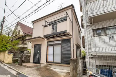 a white house with black shutters on it at \u5e61\u30f6\u8c373\u4e01\u76ee\u6238\u5efa in Tokyo