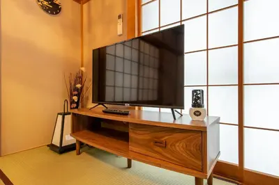 a flat screen tv sitting on top of a wooden entertainment center at \u5e61\u30f6\u8c373\u4e01\u76ee\u6238\u5efa in Tokyo