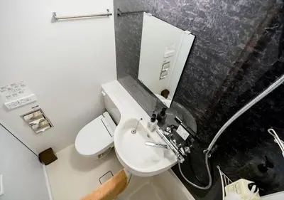 a bathroom with a sink and a toilet and a mirror at IKIDANE Residentila Hotel Komagome - Vacation STAY 17962v in Tokyo