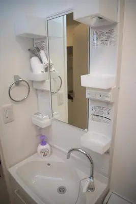 a white bathroom with a sink and a mirror at \u30d7\u30ec\u30df\u30a2\u30e0\u30b3\u30fc\u30c8\u897f\u6c60\u888b in Tokyo