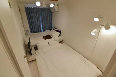 a small room with two beds and a mirror at \u30d7\u30ec\u30df\u30a2\u30e0\u30b3\u30fc\u30c8\u897f\u6c60\u888b in Tokyo
