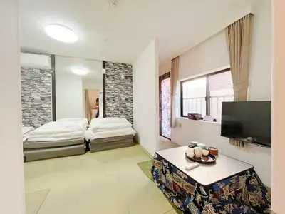 a living room with two beds and a tv at \u82b1\u4e43\u90f7 \u8d64\u7fbd in Tokyo