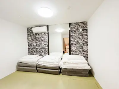 a room with four mattresses piled up against a wall at \u82b1\u4e43\u90f7 \u8d64\u7fbd in Tokyo