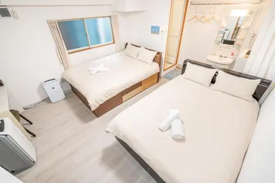 a small room with two beds and a window at Ikebukuro East Exit Queen Bed Room in Tokyo