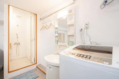 a white bathroom with a sink and a shower at Ikebukuro East Exit Queen Bed Room in Tokyo