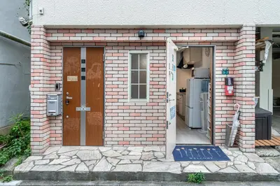 a brick house with a door and a refrigerator at Ikebukuro East Exit Queen Bed Room in Tokyo