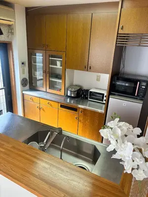 a kitchen with wooden cabinets and a sink at Koiwa Detached house \u5c0f\u5ca9\u99c5\u306b\u3042\u308b\u6238\u5efa\u306e\u304a\u3046\u3061 in Tokyo
