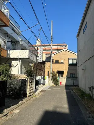 an empty street in an alley between two buildings at Koiwa Detached house \u5c0f\u5ca9\u99c5\u306b\u3042\u308b\u6238\u5efa\u306e\u304a\u3046\u3061 in Tokyo