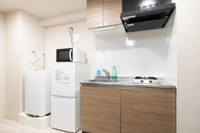 a kitchen with a white refrigerator and a sink at Lafesta\u6771\u99d2\u5f62 in Tokyo