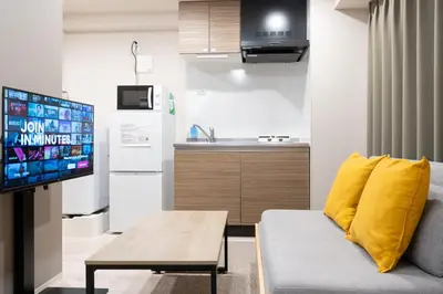 a living room with a couch and a tv at Lafesta\u6771\u99d2\u5f62 in Tokyo