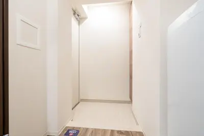 a hallway with white walls and a white door at Lafesta\u6771\u99d2\u5f62 in Tokyo