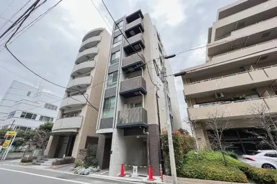 a tall apartment building with a car parked next to it at Lafesta\u6771\u99d2\u5f62 in Tokyo