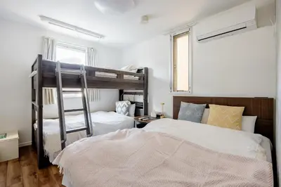 a bedroom with two bunk beds and a ladder at \u6771\u99d2\u5f62101 in Tokyo