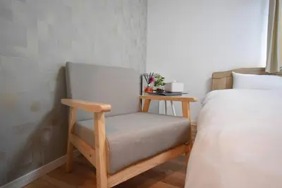 a chair sitting next to a bed in a room at \u6771\u99d2\u5f62102 in Tokyo