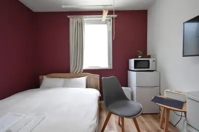 a small bedroom with a bed and a chair at \u6771\u99d2\u5f62103 in Tokyo