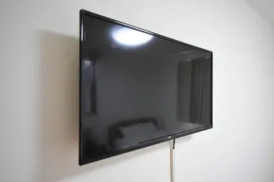a flat screen tv hanging on a wall at \u6771\u99d2\u5f62103 in Tokyo