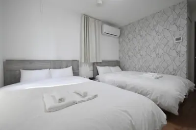two beds in a hotel room with white towels on them at \u6771\u99d2\u5f62201 in Tokyo
