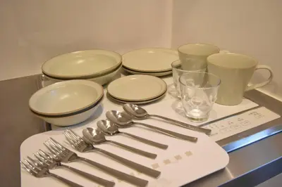 a table with forks and knives and plates and cups at \u6771\u99d2\u5f62201 in Tokyo