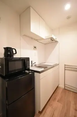 a kitchen with a black refrigerator and a stove at \u6771\u99d2\u5f62201 in Tokyo