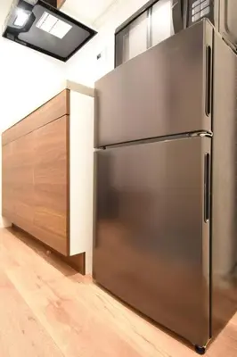 a kitchen with a stainless steel refrigerator and a wooden cabinet at \u6771\u99d2\u5f62203 in Tokyo