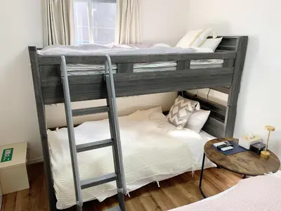 a bedroom with two bunk beds and a table at \u6771\u99d2\u5f62301 in Tokyo