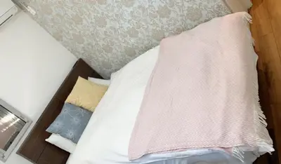 a bed with a pink blanket on top of it at \u6771\u99d2\u5f62301 in Tokyo