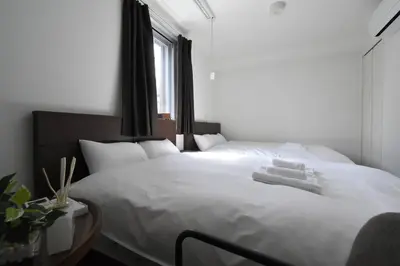 a bedroom with a large white bed with a window at \u6771\u99d2\u5f62302 in Tokyo