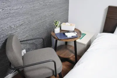 a small table with a chair and a bed in a room at \u6771\u99d2\u5f62302 in Tokyo