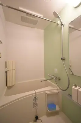 a bathroom with a shower with a mirror and a sink at \u6771\u99d2\u5f62302 in Tokyo