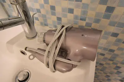 a hair dryer sitting on top of a sink at \u6771\u99d2\u5f62303 in Tokyo