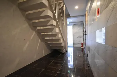 a hallway with a staircase and a tiled floor at \u6771\u99d2\u5f62401 in Tokyo