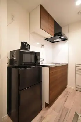 a kitchen with a microwave and a refrigerator at \u6771\u99d2\u5f62401 in Tokyo