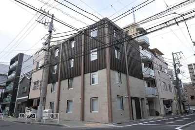 a large brick building on a city street with power lines at \u6771\u99d2\u5f62403 in Tokyo