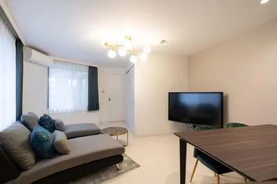 a living room with a couch and a flat screen tv at Bonheur Akasaka in Tokyo