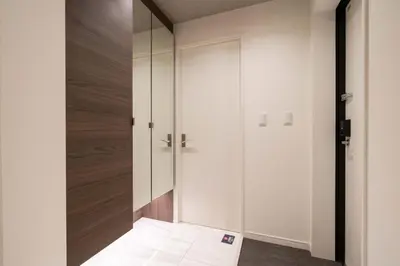 a hallway with white walls and a glass door at Bonheur Akasaka in Tokyo