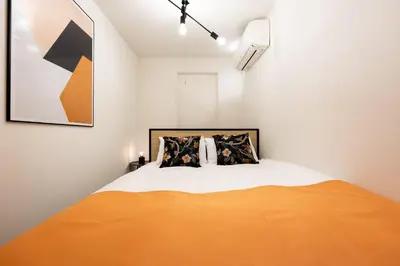 a bedroom with a bed with an orange blanket at Bonheur Akasaka in Tokyo